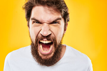 bearded man gesturing with hands studio lifestyle discontent yellow background