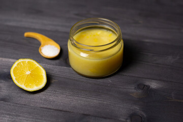 glass of lemon sauce with salt on black wooden background