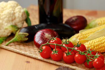 Cherry tomatoes, corn and onion on wooden table