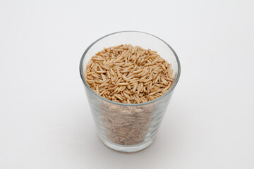 Oats in a transparent cup on white background