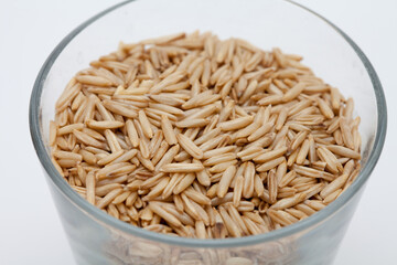 Oats in a transparent cup on white background