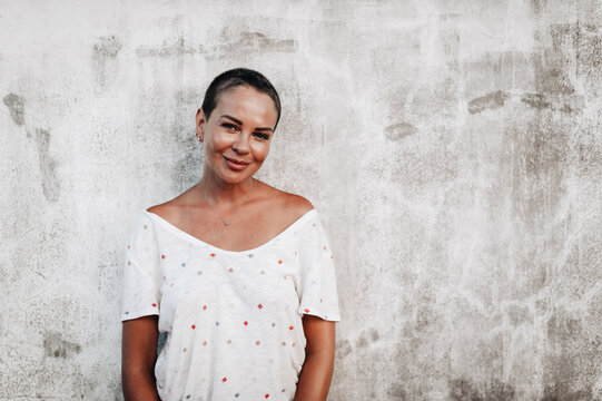 Portrait of short-haired woman standing at the wall