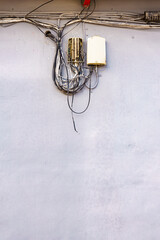 Cable power cords in tangled mess on wall outdoor