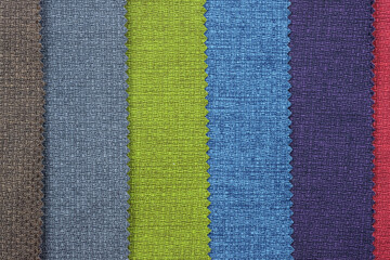 Fototapeta premium Upholstery fabric in different colors, top view. Thick fabric texture. A set of fabrics for furniture.