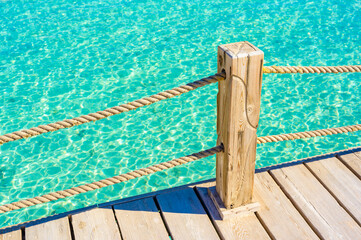 Background of wooden deck and blue water - tropical scenery in paradise travel destination