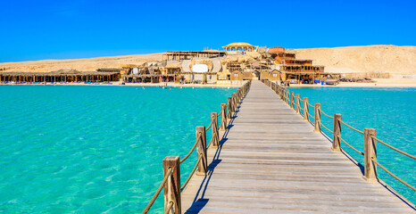Wooden Pier at Orange Bay Beach with crystal clear azure water and white beach - paradise coastline...