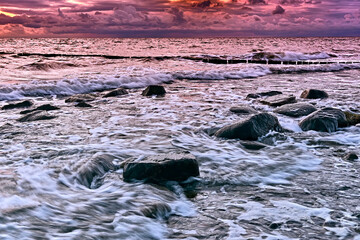 Sonnenuntergang am Steinstrand von Dranske auf der Insel Rügen.