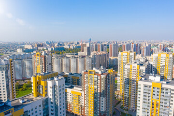 Panoramic aerial view of the city with multi storey residential buildings and highways.