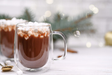 Glass cup of hot cocoa with marshmeloy christmas tree on the buckground of gold bokeh, New Year hot drink