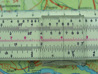 Retro Slide Rule Slipstick Used for Mathematical Calculations Over Old Map