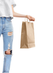 Young stylish girl figure in blue jeans with paper bag for shopping happy after buying. Shopping sale concept, isolated on white background.