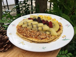 Coconut vanilla pancake with kiwi fruits and roast coconut