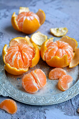 Juicy tangerines on a serving tray, vertical. Closeup