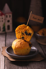 Carrot cupcakes with prunes on a wooden table.