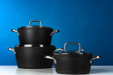 Set of black cookware against blue background