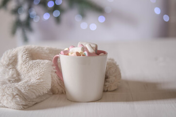 Obraz na płótnie Canvas Cup with marshmallows and white fur on a white table.