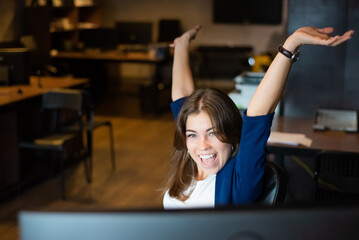 Joyful woman at her desk in the office