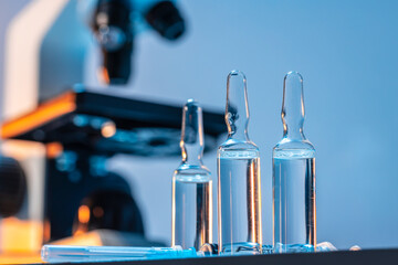 Medical vial with medication near microscope photo