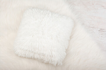 Fototapeta na wymiar White shaggy carpet and cozy pillow background. Home interior background