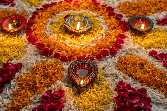 
Flower petal rangoli for Diwali with diwali diya selective focus
