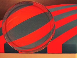 bright red and black curved diagonal stripes into intricate geometric shapes patterns and designs with a glass sphere 