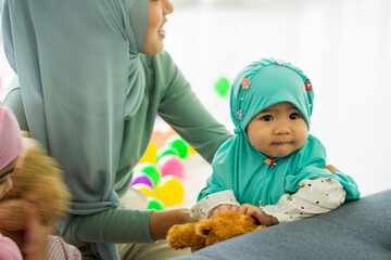  Muslim baby girl in green HIJAB playing at home with mom work from home new normal in new year festival 