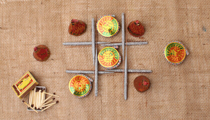 diwali firecrackers arranged in tick tack toe game form isolated on jute.