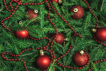 Background texture of Christmas tree branches with red baubles and beads