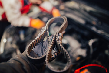 automotive timing belt in the hand of an auto mechanic.