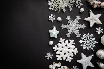 Christmas holidays composition with white christmas decorations and snowflakes on black background with copy space for your text