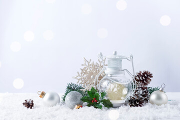 Christmas lantern on snow with fir branch and winter decoration on white