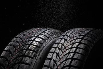 Winter Car tire and rain drops on black background