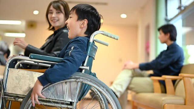 病院の待合室。車椅子にのった男の子が楽しそうにしている。