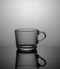 Empty tea cup on dark background with back light