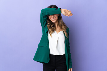 Young caucasian woman isolated on purple background covering eyes by hands