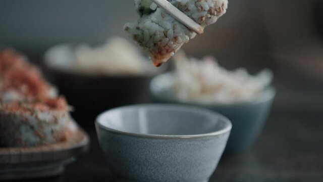 Elle mange des sushis au restaurant.