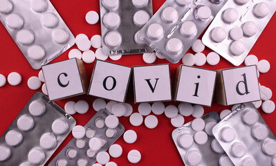 White pills on a red background with the word 