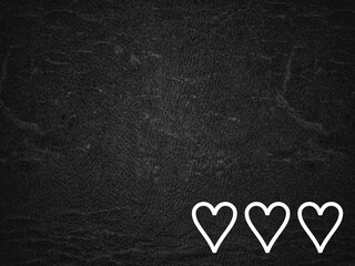 White heart shape drawn on blackboard or a black textured background with textures