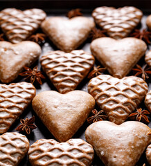 Christmas heart-shaped gingerbread cookies on a dark background close up view. Traditional festive dessert
