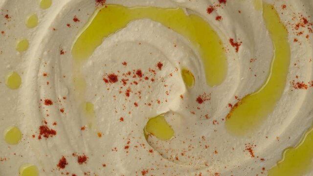 hummus with smoked paprika and olive oil top view rotating. Healthy vegan food