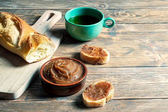 French breakfast - bread with chestnut cream, french baguette and a cup of tea on an old wooden table