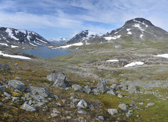 Fototapeta na wymiar Snowy peakes and lakes of Jotunheimen mountains, Norway