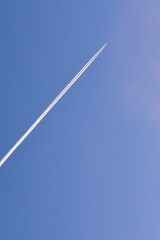 Airplane leaving white trail in the blue sky