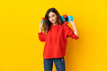 Young caucasian woman isolated on yellow background with a skate with happy expression