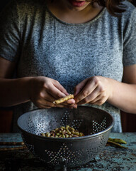 hands shelling beans over a bowl