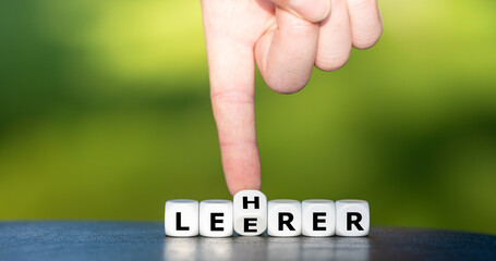 Symbol für eine bessere Bildung. Hand dreht Würfel und ändert das Wort Leerer in Lehrer.