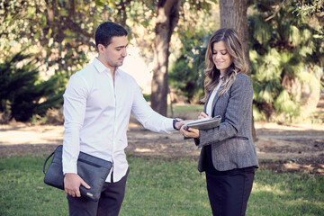 young couple of executive businessmen negotiating in a park. horizontal format