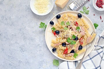 Fusilli pasta with tuna, olives, tomato and parmesan cheese. Top view with copy space. Healthy food.