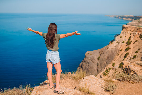 Tourist Woman Outdoor On Edge Of Cliff Seashore