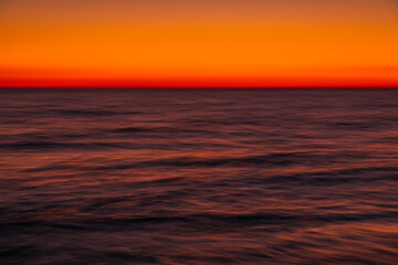 Ocean with waves at bright sunset or sunrise shooting with exposure